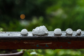 Pieces of ice on the railing after hailstorm