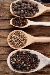 Row of wooden spoons with spices on vintage background, close-up, selective focus, vertical.
