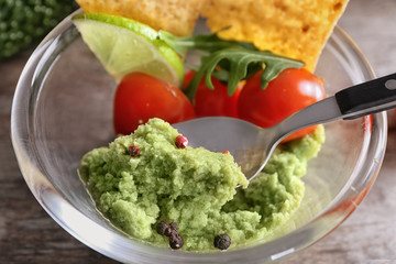 Bowl with delicious guacamole and vegetables, closeup