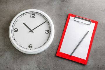 Clock with clipboard on grey background. Time management concept