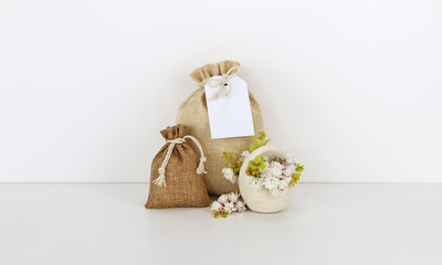 Fototapeta na wymiar Bags with empty tag mockup, flowers