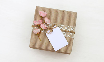 Gift box with empty tag mockup, flowers