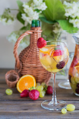 Homemade refreshing fruit sangria or punch with champagne, strawberries, oranges and grapes.