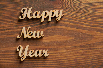 Fototapeta premium Happy New Year! - A phrase with wooden letters on a wooden backg
