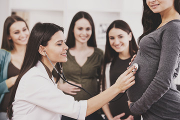Pregnant woman being examined by doctor