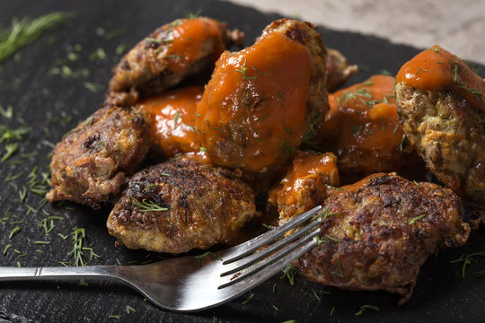 Romanian traditional food "chiftele" or "parjoale" with tomato sauce