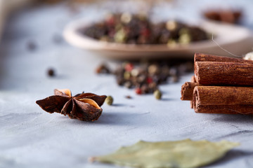 Dessert spices and wooden spoon on white textured background, close-up, shallow depth of field.