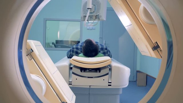 Tomographic scanning platforms. MRI scanner, tomograph with patient getting medical exam.