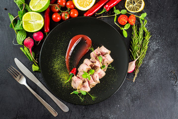 Fresh ham with sauce on black background