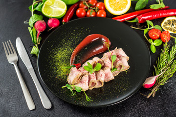 Fresh ham with sauce on black background