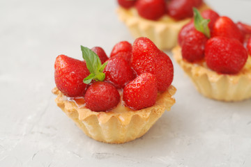 Sweet Dessert Tartlets with Strawberries and Cream Isoalted over Gray Textured Background. Summer Sweet Cakes.