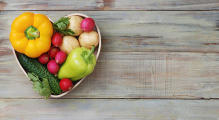 Healthy organic foods vegetables in wooden heart shape box on rustic background. Top view. LOVE for Vegetarian Food. Copy space.