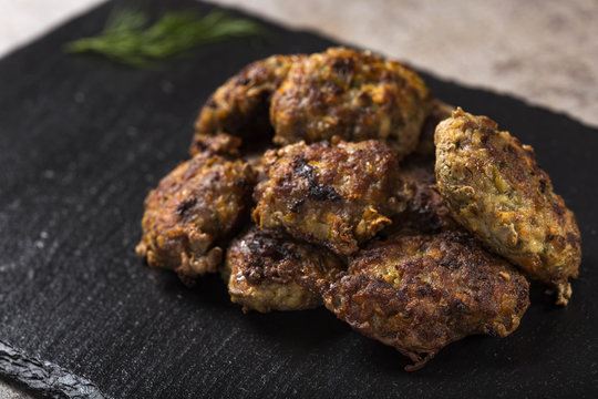 Romanian traditional food "chiftele" or "parjoale" on dark slate