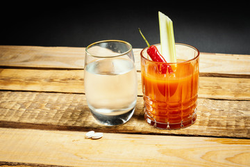 delicious bloody mary and water and pills for a hangover on a wooden table