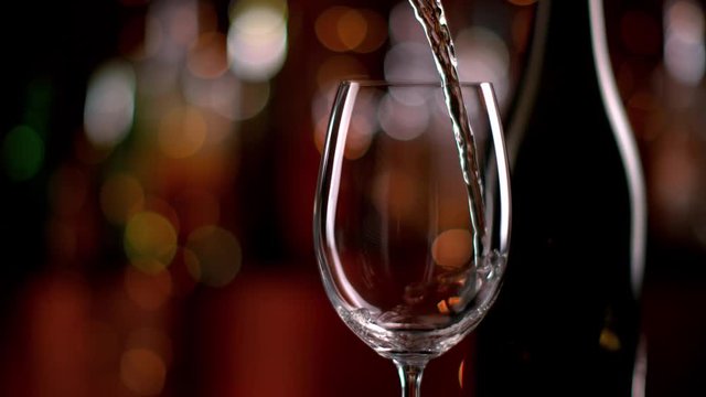 Super slow motion of pouring white wine from bottle into goblet, 1000fps. Filmed on high speed cinema camera with 1000fps 4K resolution.