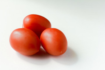 plum-shaped red tomatoes on white background