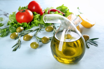 Bottle with fresh olive oil on table