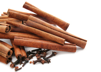 Cinnamon sticks and cloves on white background