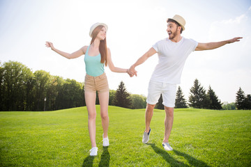 Portrait of crazy childish couple in straw hats shorts holding hands laughing having good mood. Rest relax free time outdoo sun sunshine sunlight weather daydream sunny day concept