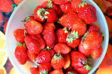 A plastic bowl with strawberries.