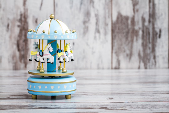 Blue Carousel Music Box on White Wooden Background, Copy Space
