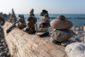 Fototapeta na wymiar Stone stacks on driftwood