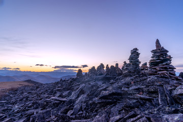 stack of balance stone on top of mountain with sunrsie in tibet