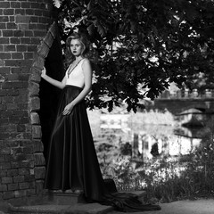 Fashion style photo of young beautiful woman in evening dress with white top and red flying skirt...