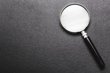 magnifying glass on  black texture  background.