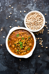 Black Eyed Kidney Beans Curry or Chawli chi usal / Barbati masala, served in a ceramic bowl over moody background, selective focus   © StockImageFactory