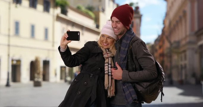 Happy young couple taking a selfie in Rome, Portrait of male and female tourists taking a picture with smartphone, 4k