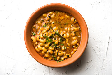 Black Eyed Kidney Beans Curry or Chawli chi usal / Barbati masala, served in a ceramic bowl over moody background, selective focus
