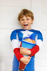 little kid boy with traditional German school bag in superhero costume
