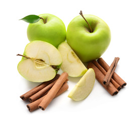 Fresh apples and cinnamon sticks on white background