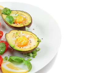 Tasty baked avocado with eggs on plate against white background