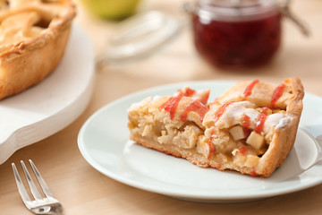Plate with piece of tasty homemade apple pie on table