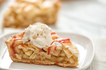 Piece of tasty homemade apple pie with ice cream on plate