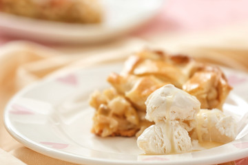 Ice cream and piece of tasty homemade apple pie on plate, closeup