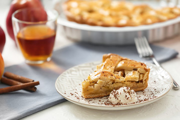 Plate with piece of tasty homemade apple pie and ice cream on table