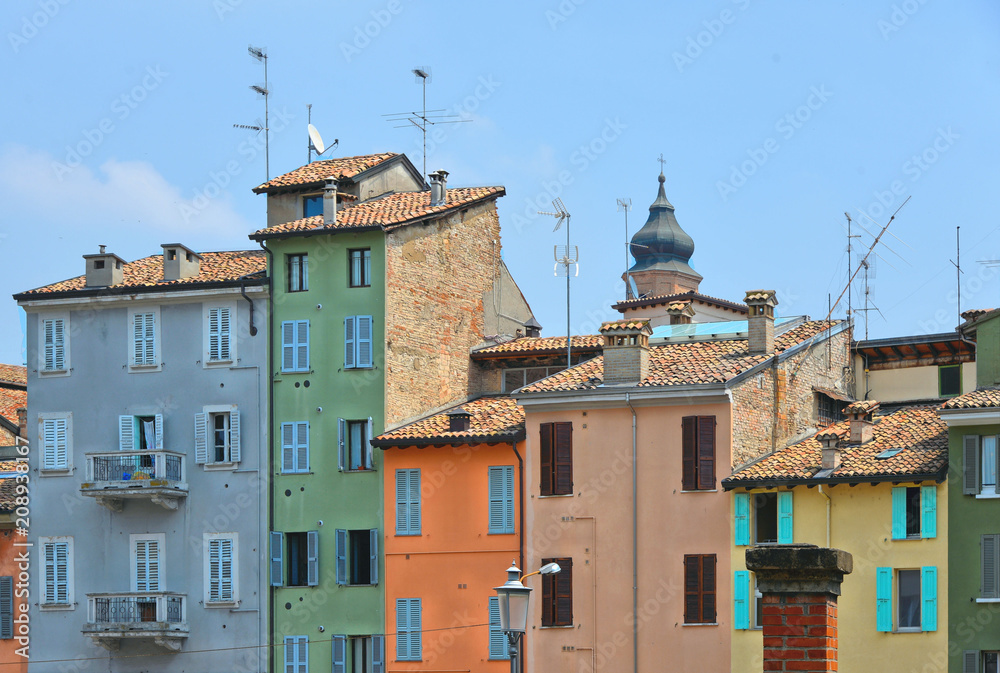 Wall mural parma colorful buildings and facades in front of city open market with cloudy blue sky, italy