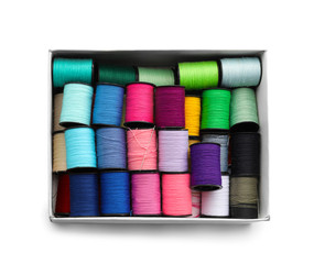 Box with colorful sewing threads on white background