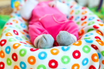 Cute adorable newborn baby playing on colorful toy gym