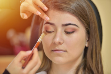 Makeup artist creating beautiful makeup for bride before the wedding