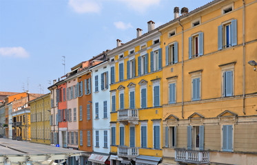 parma colorful buildings and facades in front of city open market with cloudy blue sky, Italy