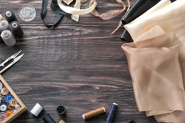 Frame made of sewing accessories on wooden background