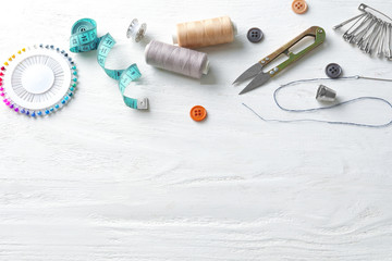 Fototapeta na wymiar Sewing accessories on white wooden background