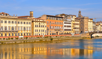 Fototapeta na wymiar colorful buildings and water reflections on river in florence, italy
