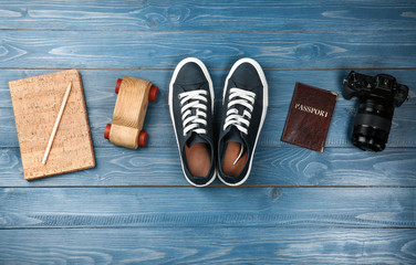Composition with tourist's stuff on wooden background, top view