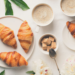 Breakfast on white flat lay with coffee and croissants