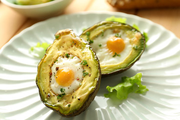 Baked avocado with eggs on plate, closeup